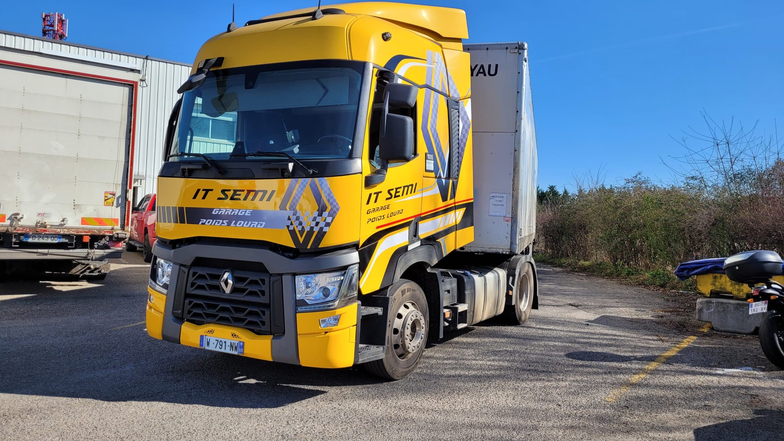 Camion Renault IT SEMI Jaune – Expert Garage Poids Lourd Camion Renault IT SEMI jaune stationné, texte Garage Poids Lourd, plaque W-791-NW, sous un ciel bleu.